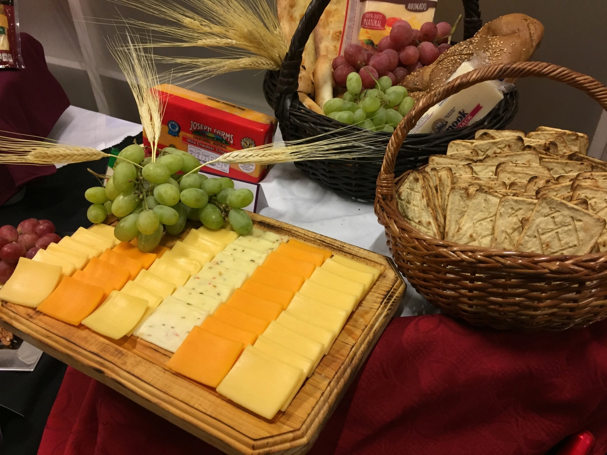 tabla de quesos con canasta de uvas y pan