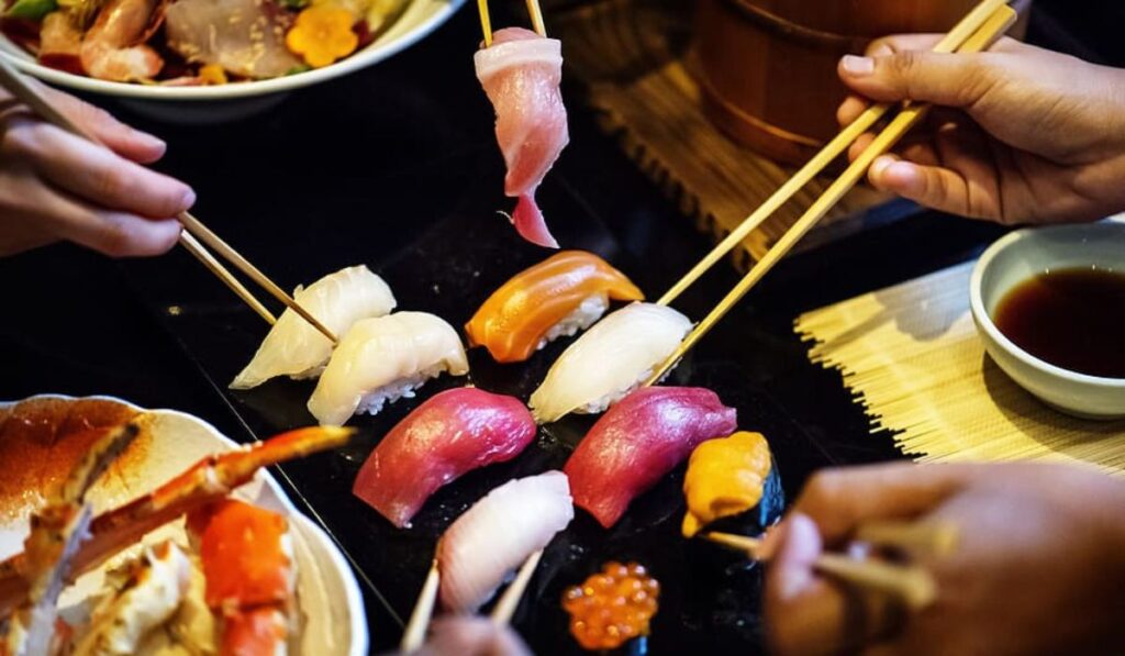 Ejemplo de nigiris al centro, forma de comer sushi o platillos japoneses.