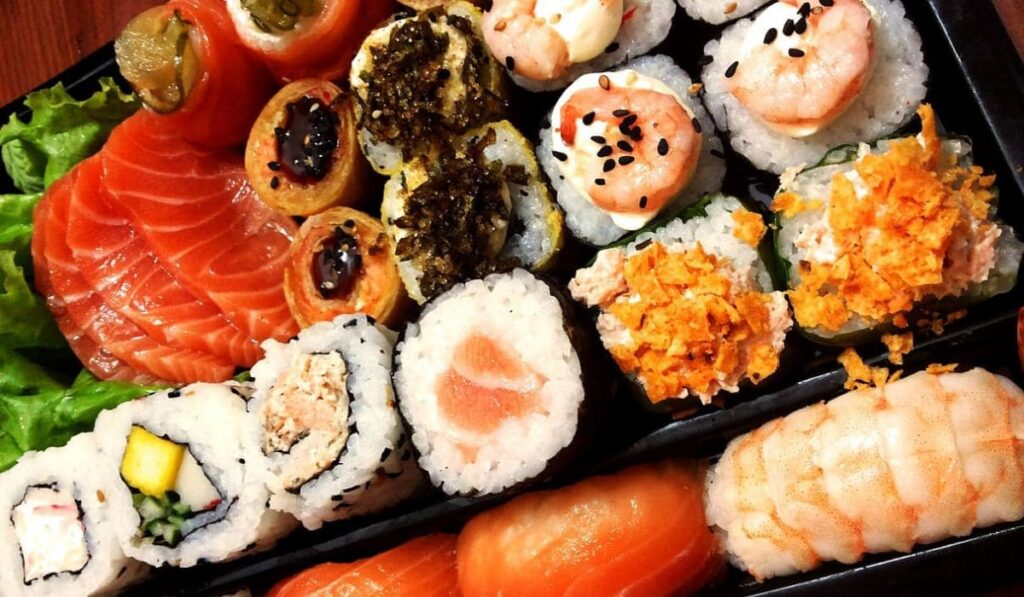 Plato al centro con sushi, nigiris y sashimi. 