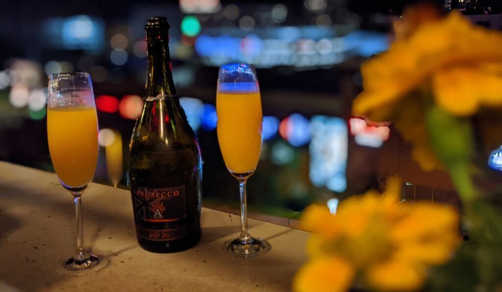 Imagen ilustrativa de copas de mimosa y botella de Prosseco