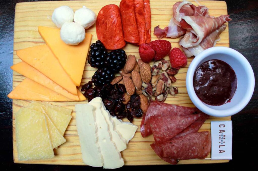 Foto en la que se ve una tabla con distintos quesos y embutidos en Terraza Camila