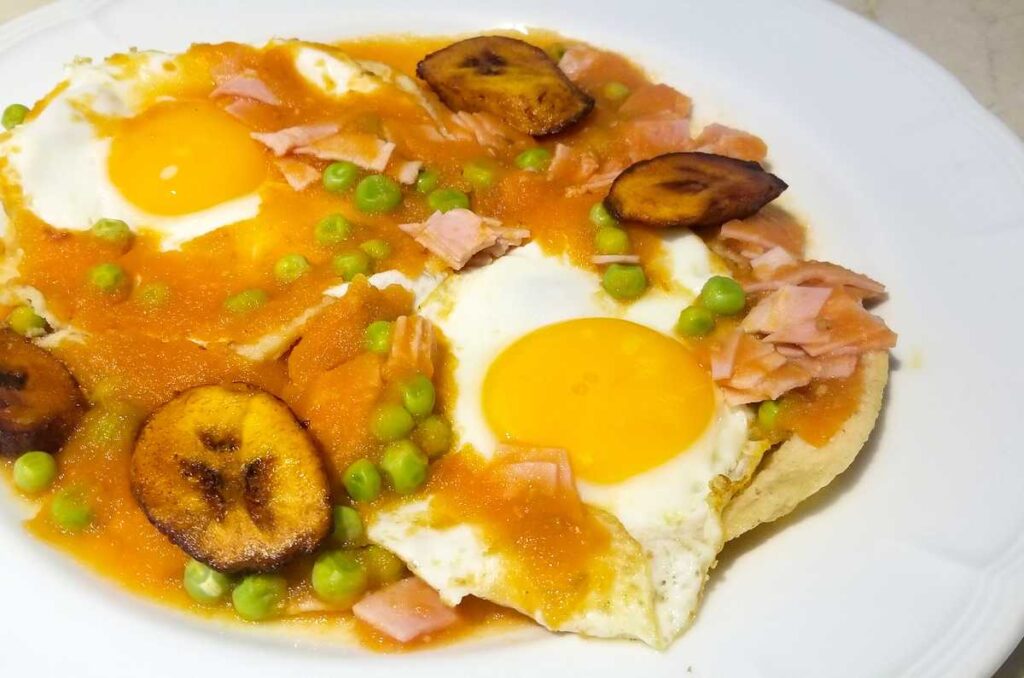 Foto de huevos motuleños servidos con chícharos y plátano frito