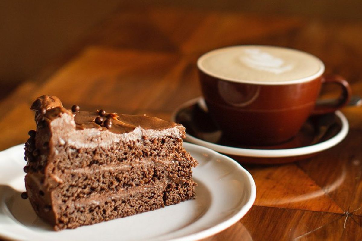 Rebanada de pastel acompañada de taza de café. Foto de Instagram Belmondo.