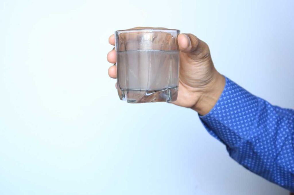 Foto de vasos mal lavados en la mano de una persona