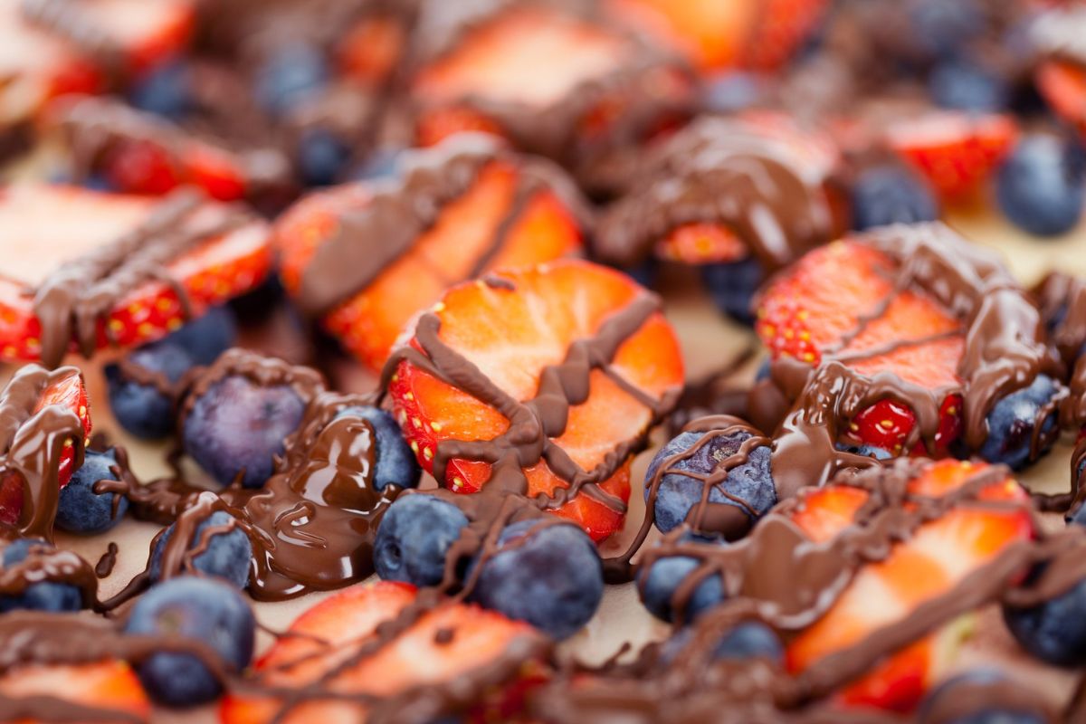 Fresas y arándanos frescos con chocolate. Foto de Canva.