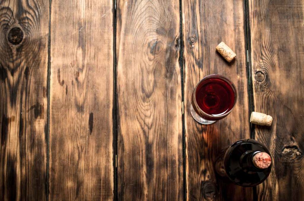 Foto de una copa de vino con corchos al lado