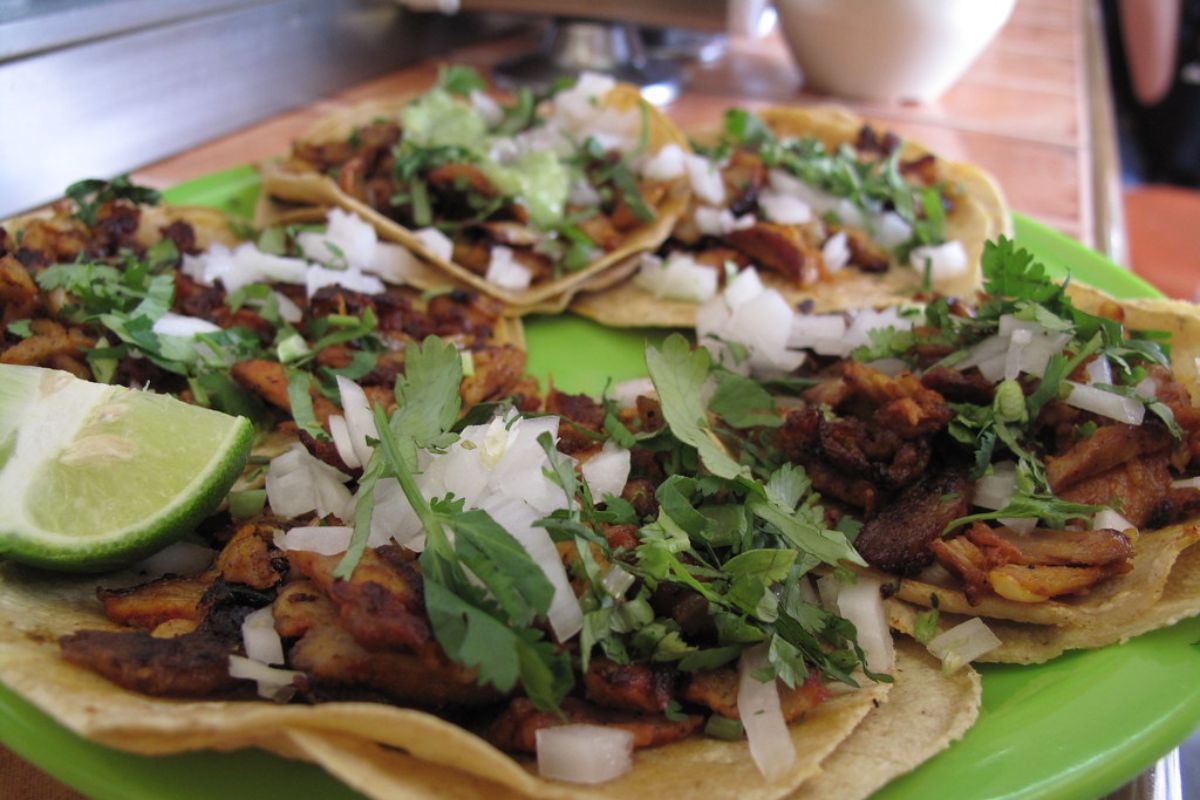 Tacos al pastor preparados con cebolla y cilantro fresco. Foto de Flickr.