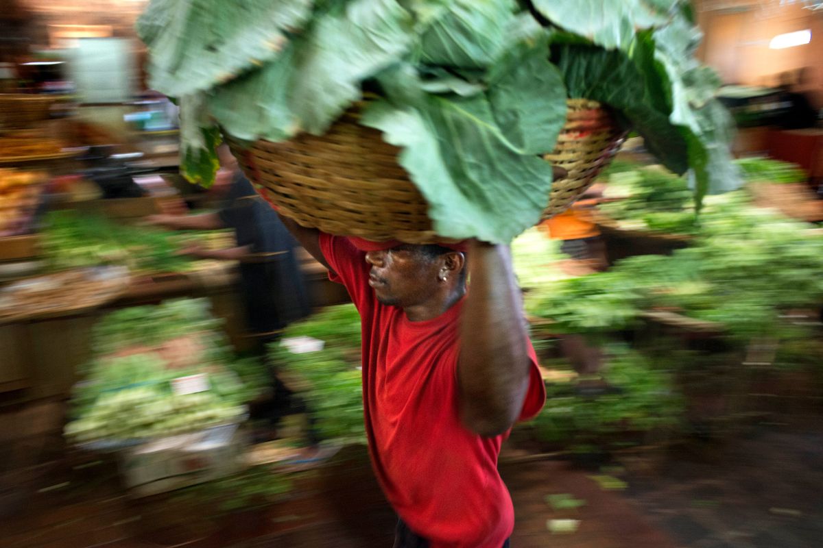 Hombres locales cargando productos en el mercado. Foto por Sergi Reboredo.