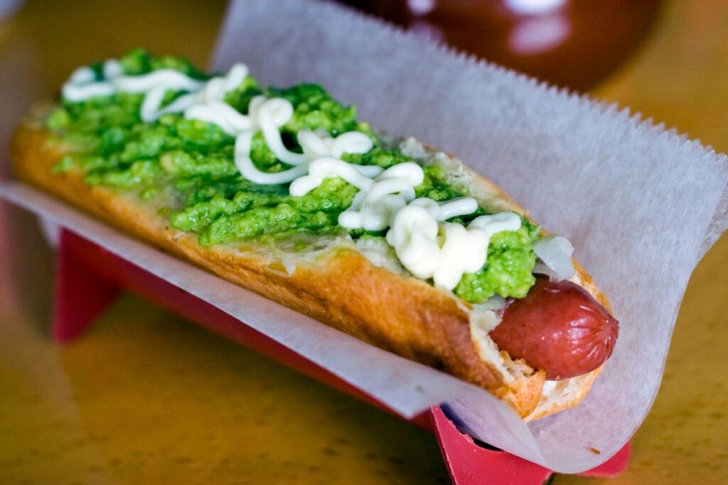 La versión chilena del hot dog se prepara con mayonesa, puré de aguacate y jitomate fresco.