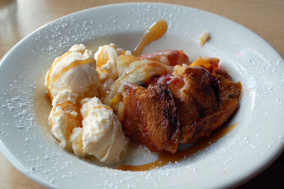 Peach cobbler servido con helado de vainilla. Foto de Flickr.