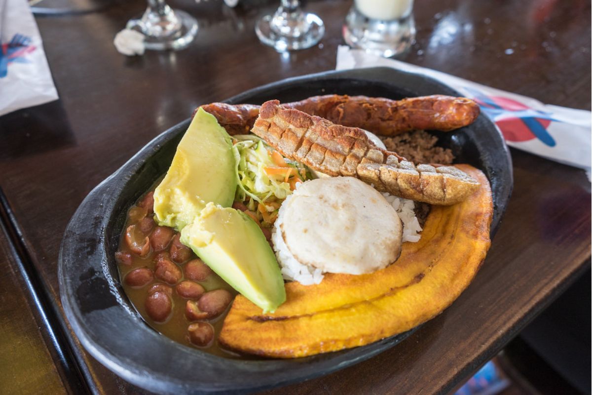 Platillo colombiano servido con huevo frito, plátano macho, chicharrón y aguacate. Foto de Flickr.