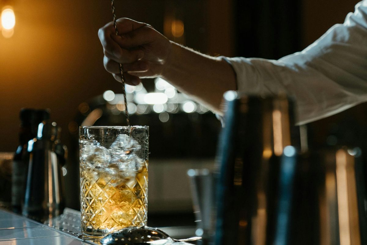 Bartender preparando trago con hielo. Foto de Pexels.