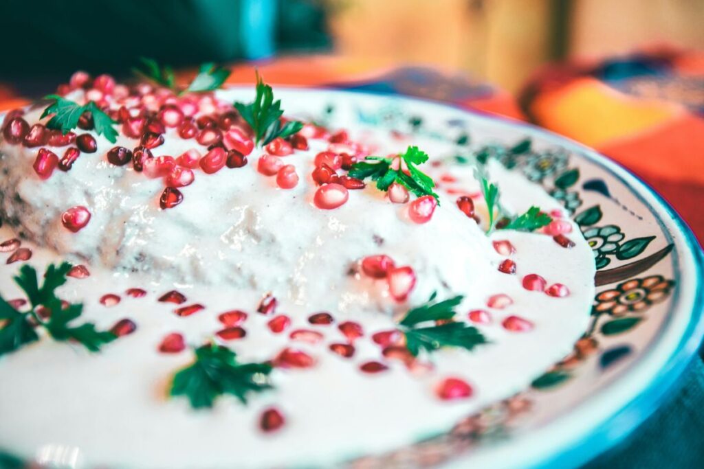 La nogada es una salsa espesa que cubre al chile poblano relleno.