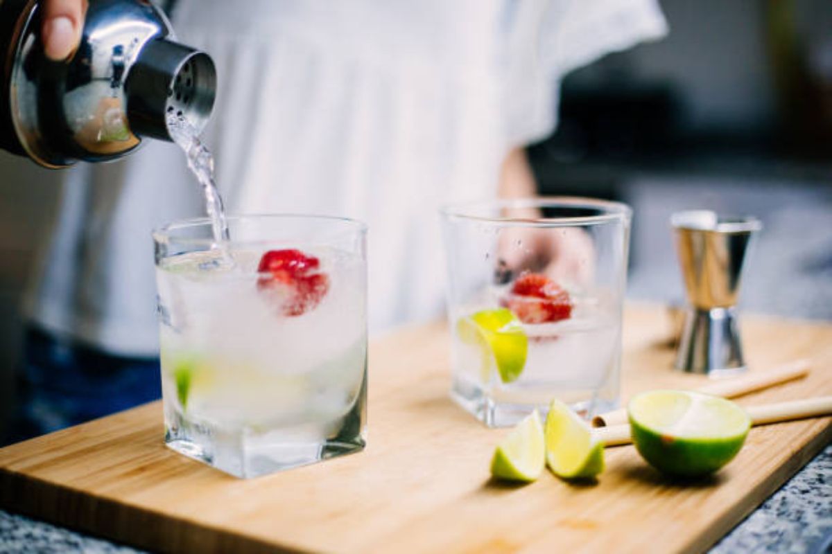 Persona preparando coctel con fresas y limón fresco. Foto de Pexels.