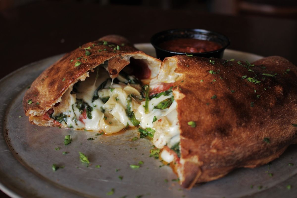 Platillo hecho con masa relleno de queso, espinaca y jitomate. Foto de Pexels.