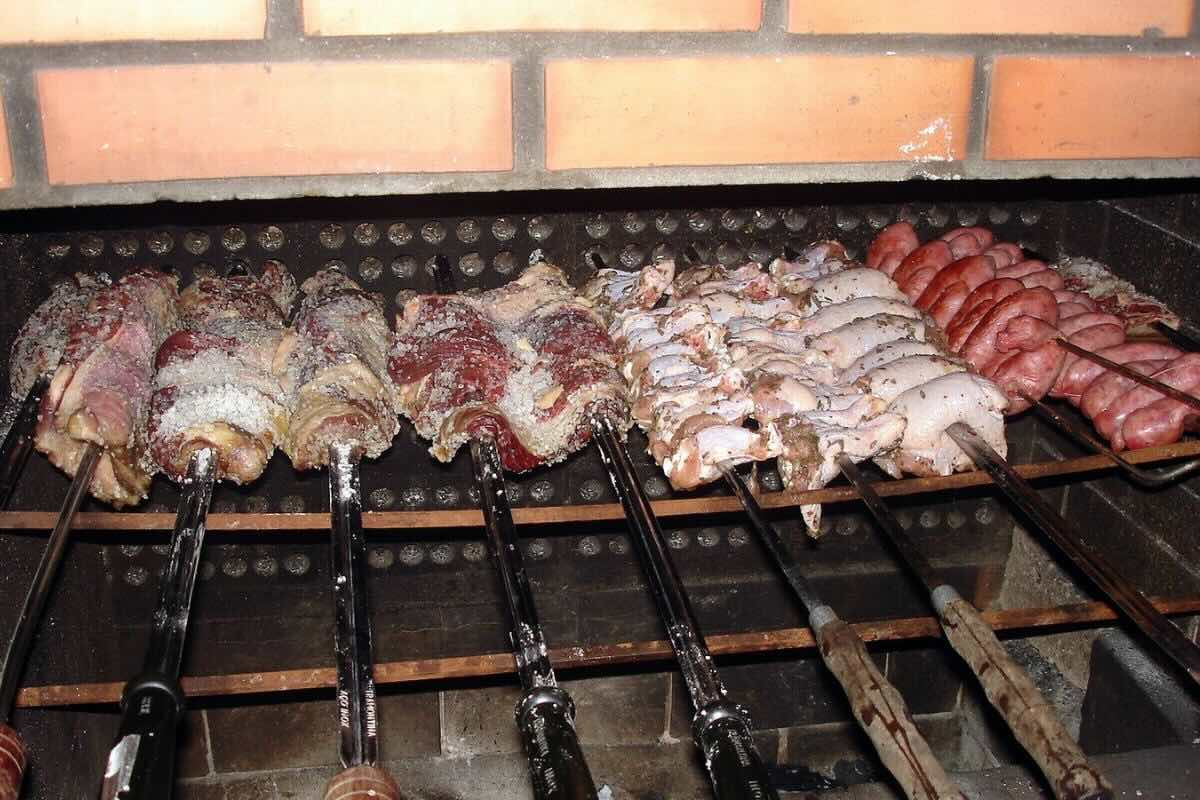 Carne de res y embutidos cocinados a las brasas. Foto de Flickr.