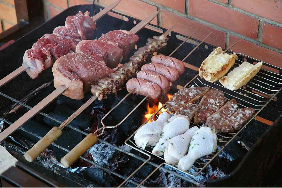 Carne de res y embutidos cocinados a las brasas. Foto de Flickr.