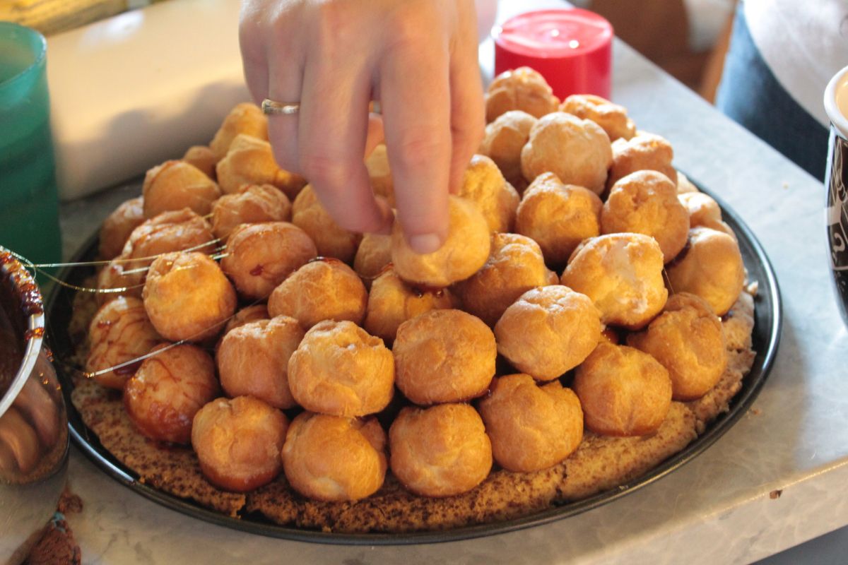 Persona armando torre con profiteroles rellenos. Foto de Flickr.