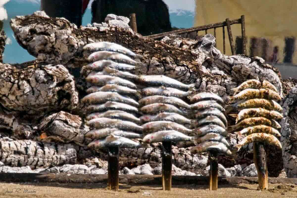 Proceso de cocción de sardinas en la playa. Foto de Flickr.