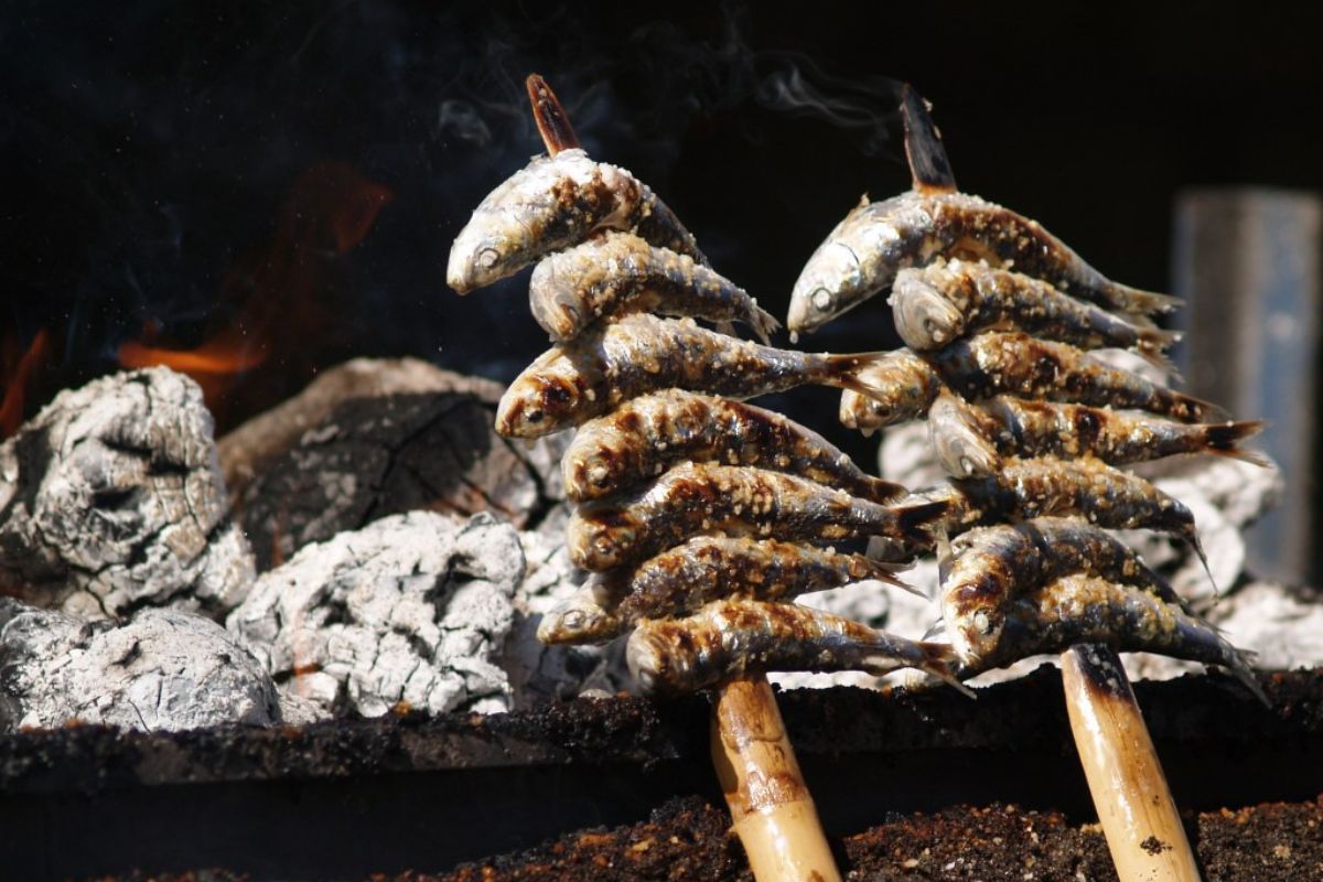 Proceso de cocción de sardinas en la playa. Foto de Flickr.