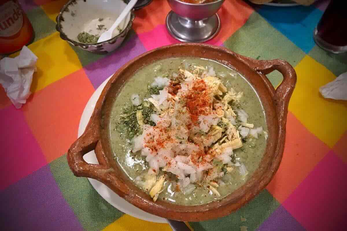 Pozole verde con cebolla y chile en polvo. Foto de Flickr.