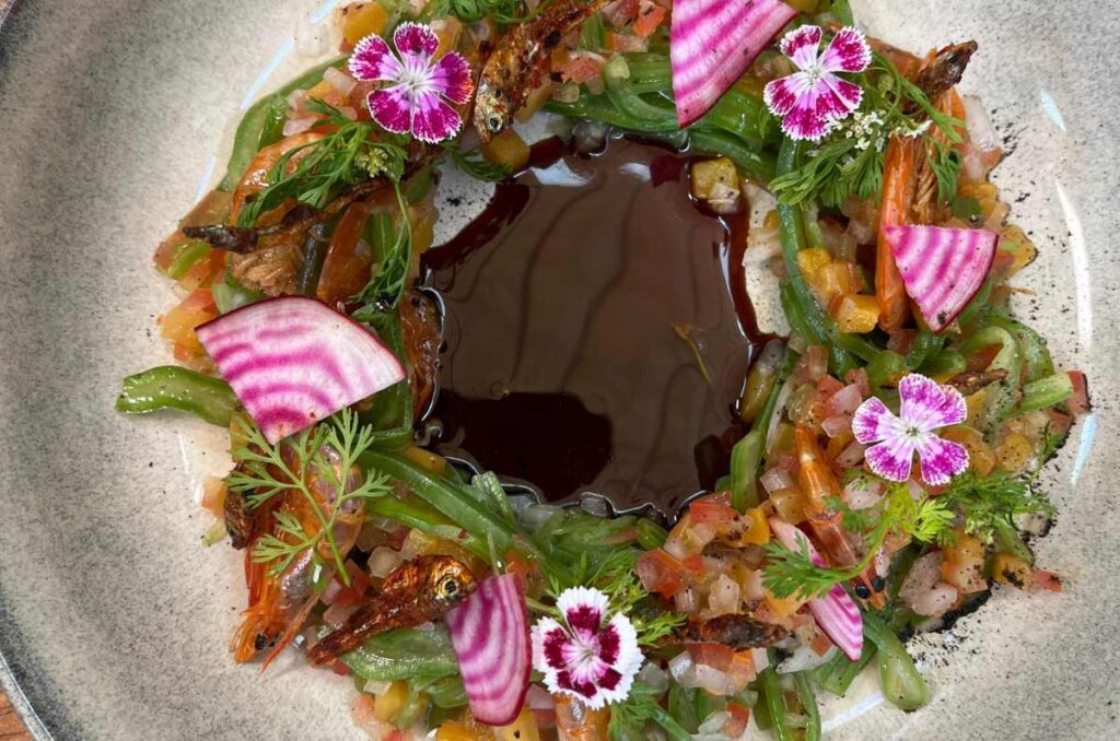 Plato con una ensalada de npales y un espejo al centro