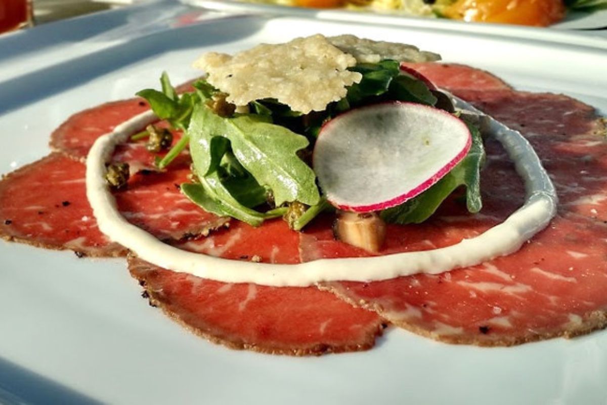 Carpaccio de res con hierbas frescas y rábanos. Foto de Flickr.