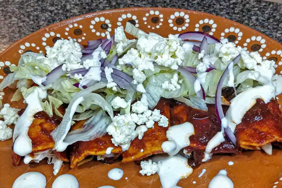 Enchiladas rojas con lechuga, crema y queso. Foto de Flickr.