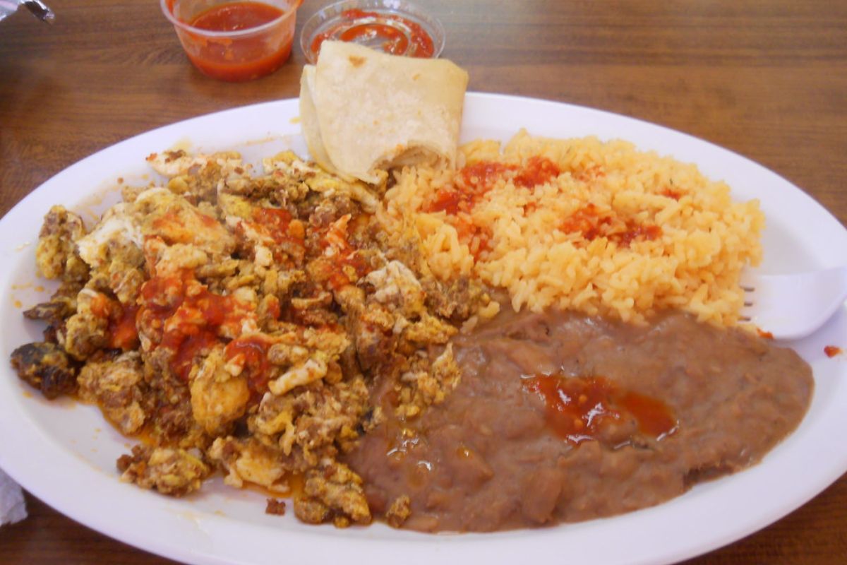 Desayuno con huevo revuelto con chorizo, guarnición de arroz rojo y frijoles refritos. Foto de Flickr.