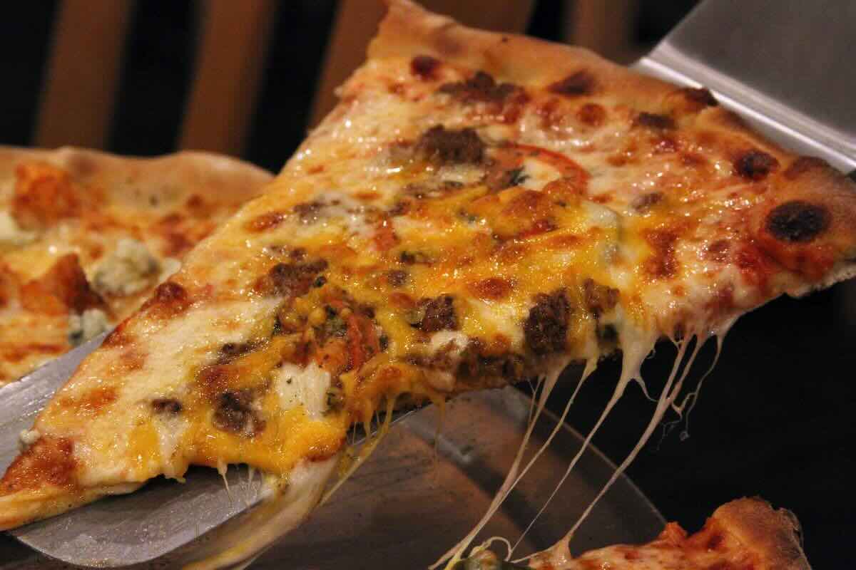 Rebanada de pizza recién horneada. Foto de Pexels.