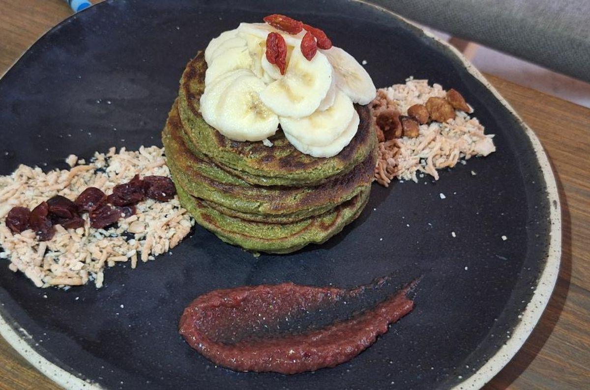 Pancakes con harina de avena, espinaca y plátano con topping de fruta de temporada, coco tostado, nuez rallada y agave en Mera, foto de Miriam Carmo