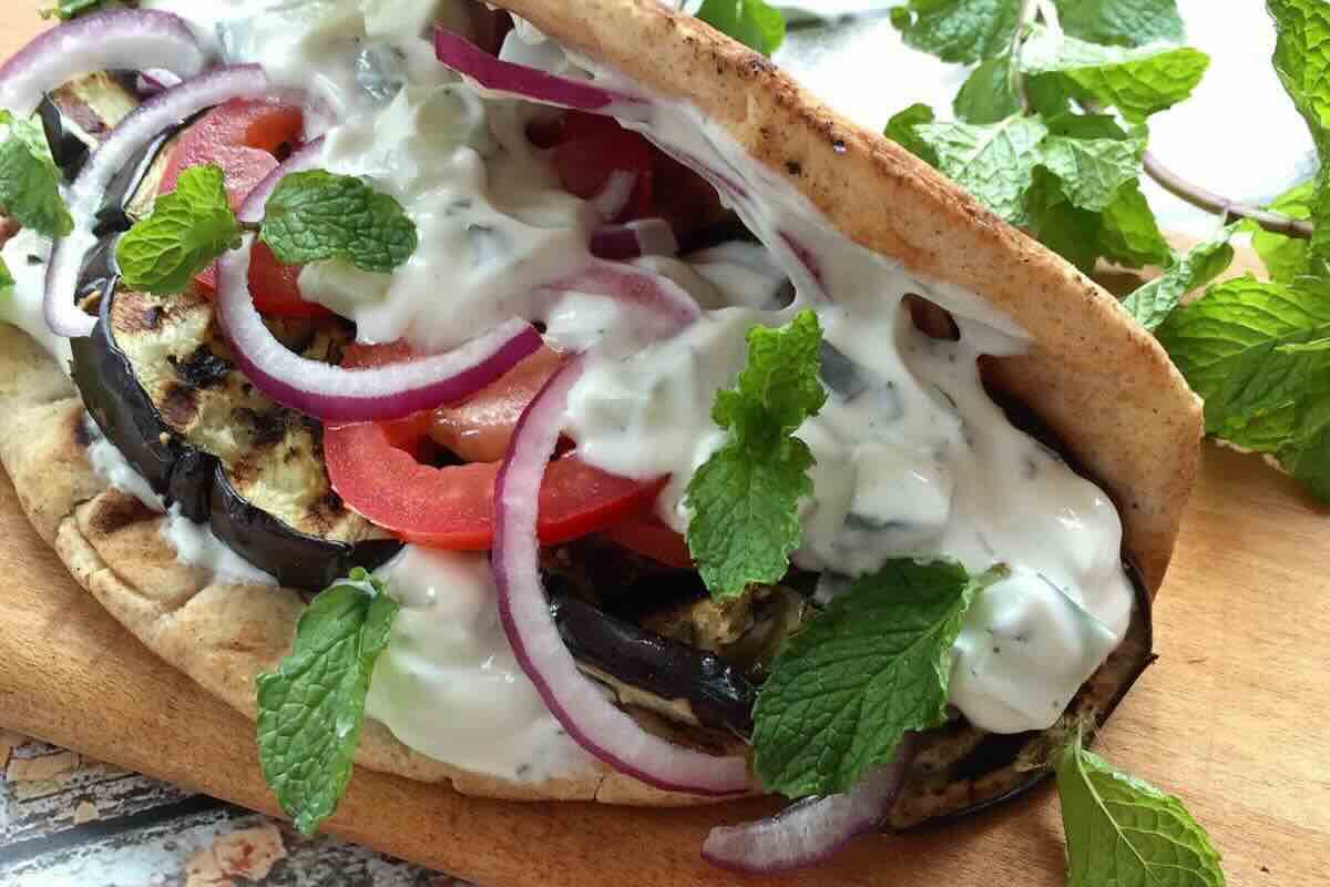 Kebab de carne con ensalada fresca y tzatziki. Foto de Flickr.