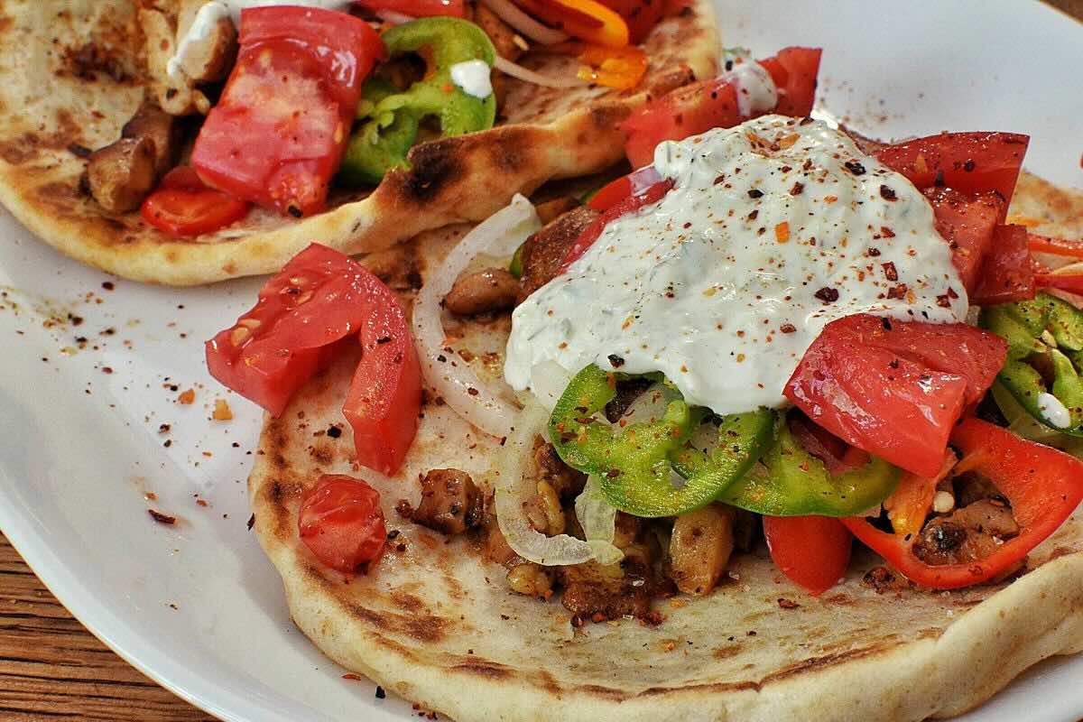 Kebab de carne con ensalada fresca y tzatziki. Foto de Flickr.