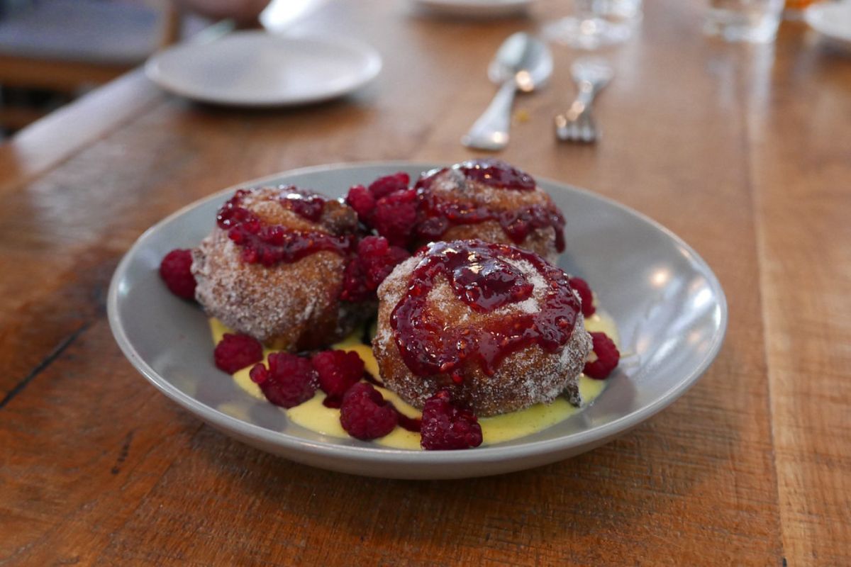 Postre de masa frita con crema pastelera y mermelada de frutos rojos. Foto de Flickr.