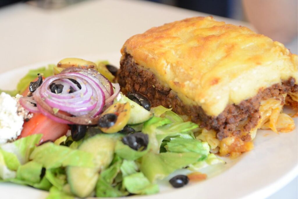 El pastitsio se prepara con pasta y salsa de carne, pero no lleva queso.