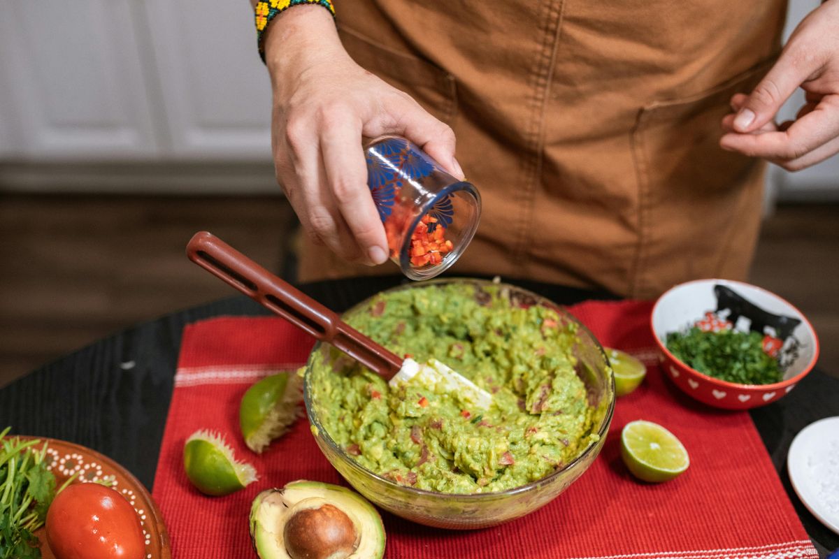 Persona preparando guacamole. Foto de Pexels.