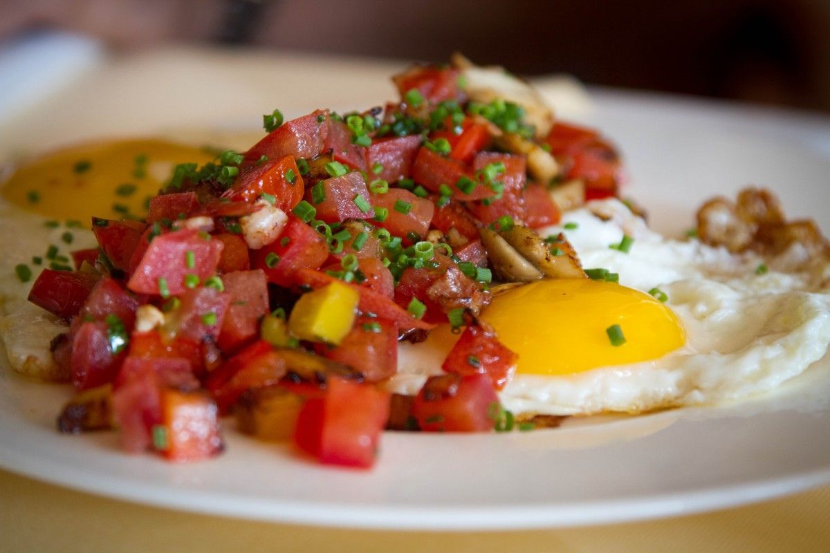 Huevos estrellados con pico de gallo (jitomate, cebolla y cilantro). Foto de Flickr.