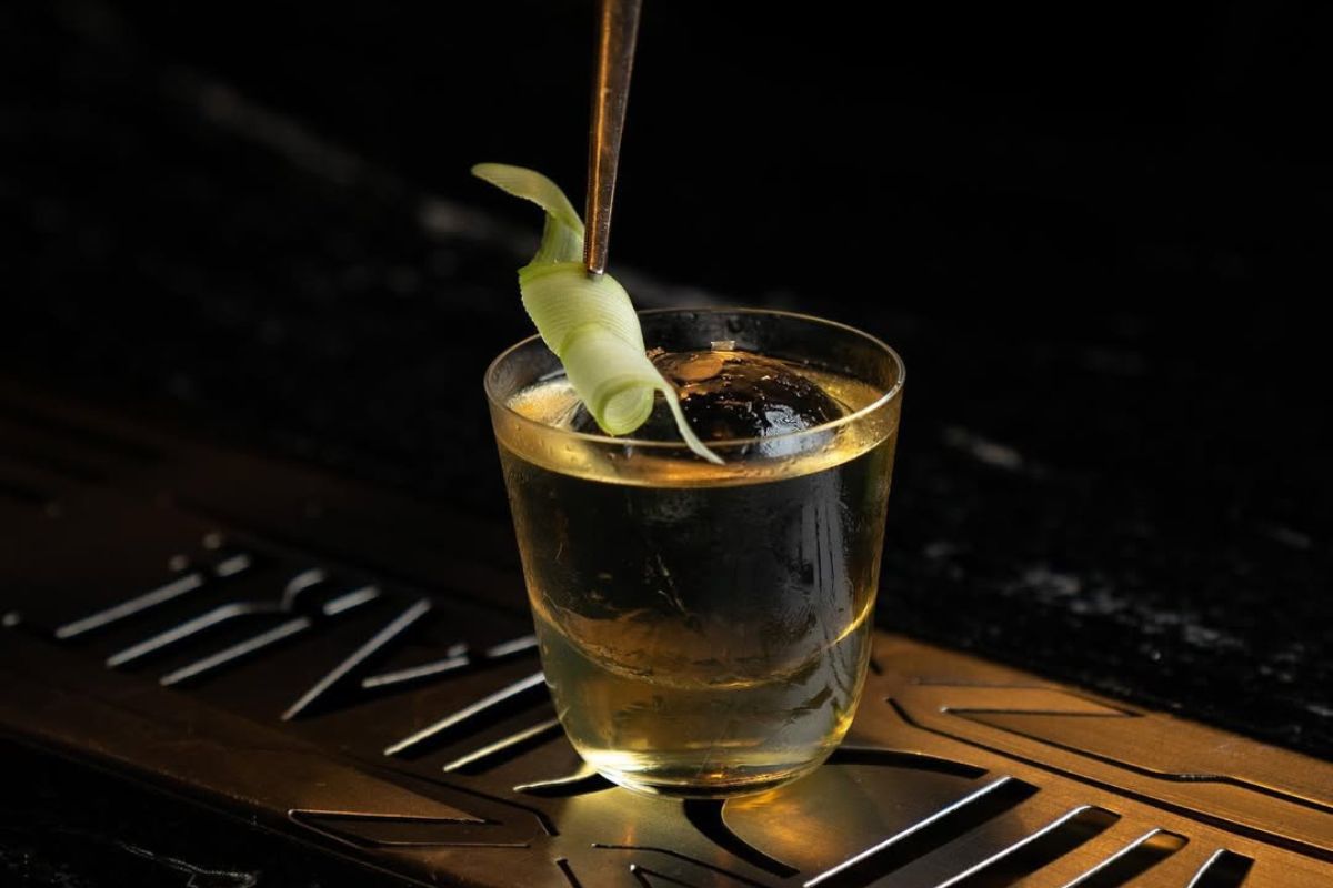 Persona alistado detalles en coctel. Foto de Instagram Handshake Speakeasy.