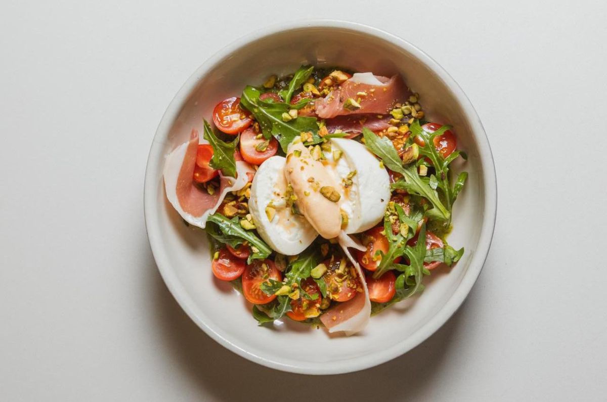 Ensalada de burrata con jitomate cherry, pesto de pistache, jamón serrano y helado de melón, foto proporcionada por el restaurante