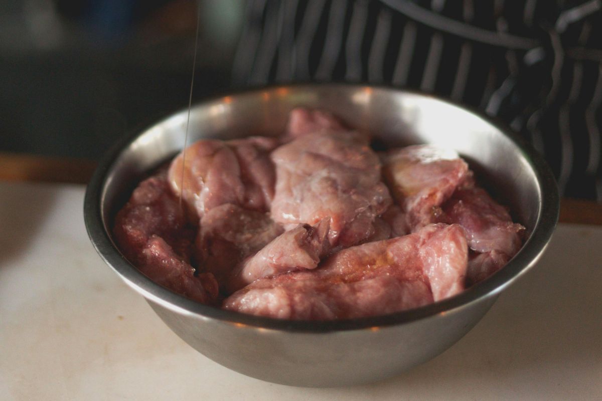 Piezas de pollo crudo con condimentos. Foto de Pexels.