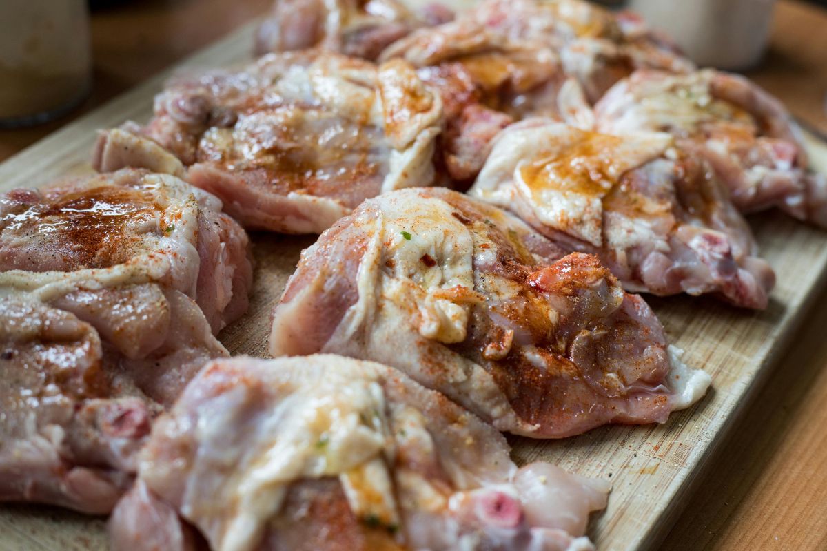 Piezas de pollo crudo con condimentos. Foto de Pexels.