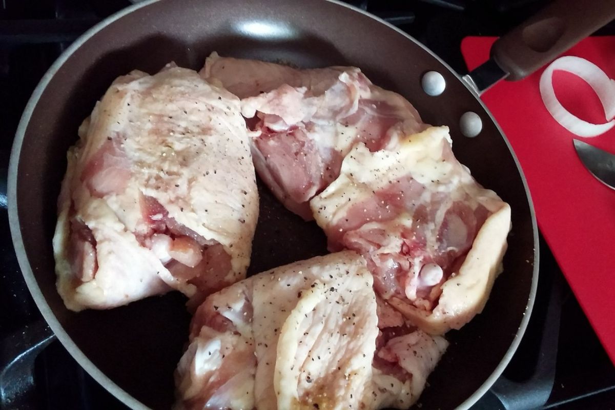 Pollo crudo con piel. Foto de Pexels.