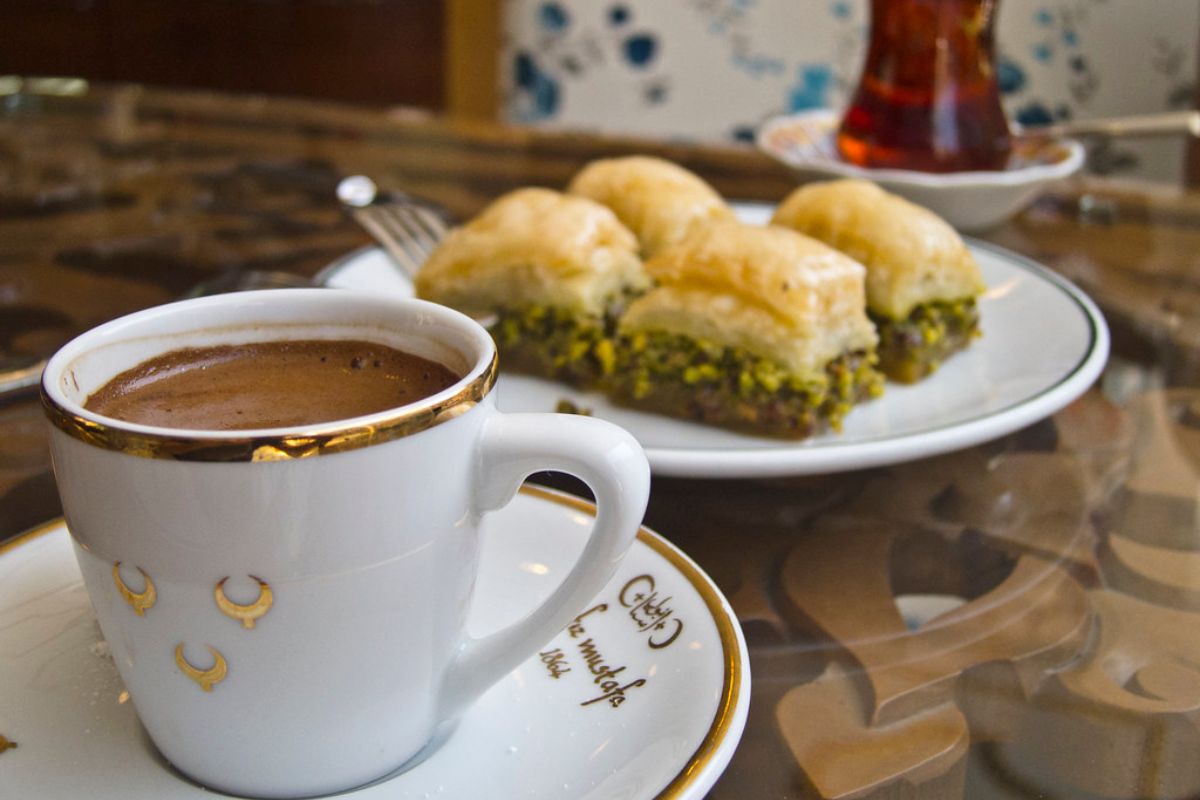 Taza de café acompañando bocadillos dulces. Foto de UnSplash.