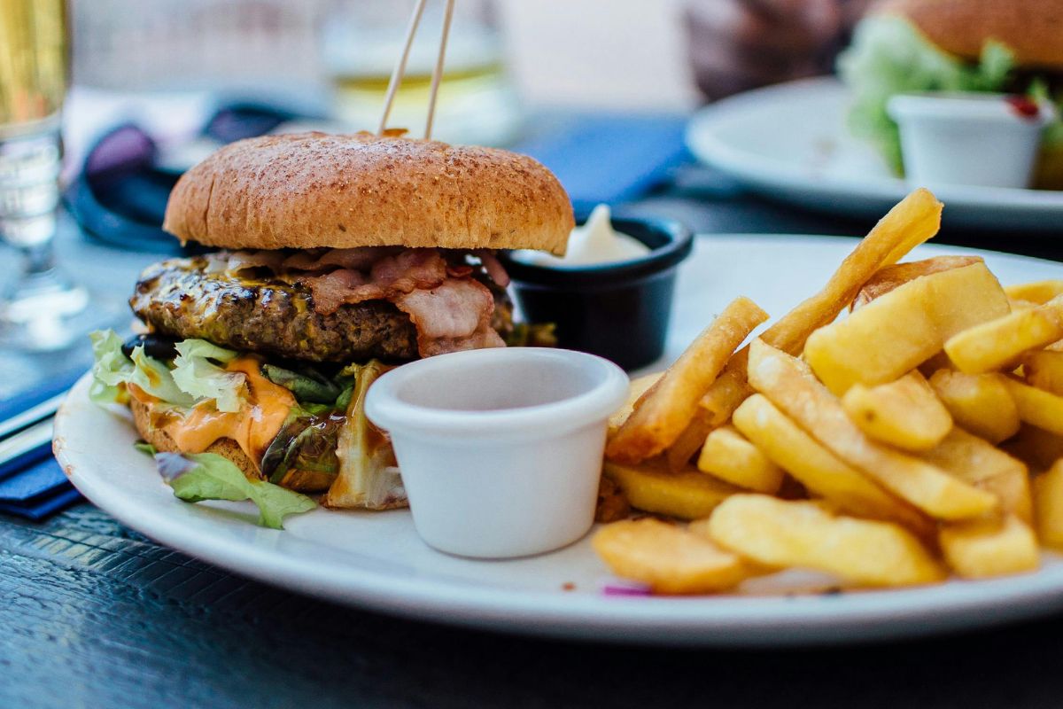 Hamburguesa acompañada de papas a la francesa. Foto de Pexels.
