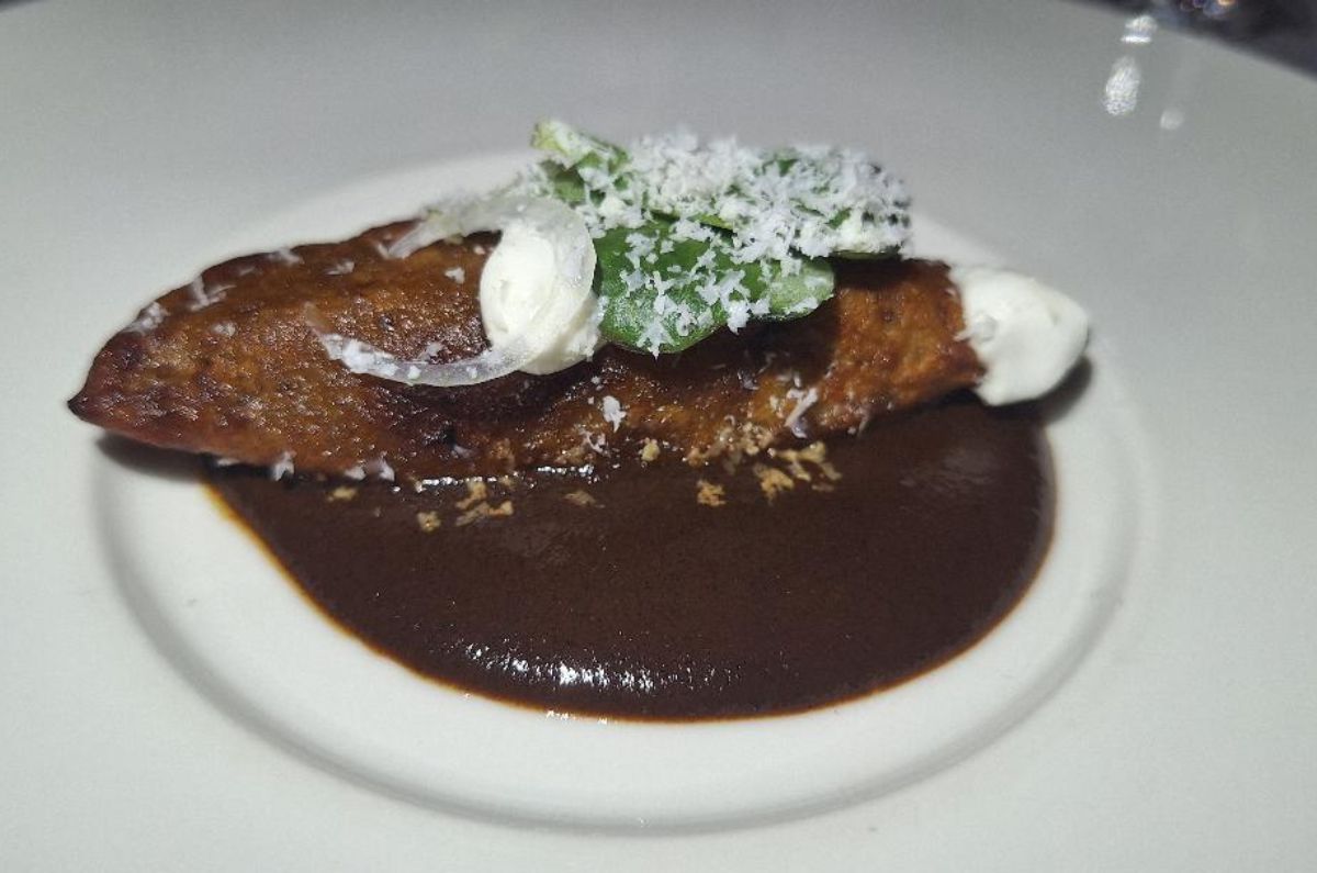 Empanada de plátano macho rellena de lechón en espejo de mole negro, foto de Miriam Carmo