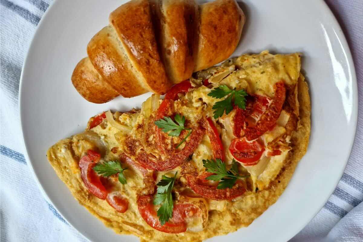 Desayuno con huevo, jitomate y pan dulce. Foto de Pexels.