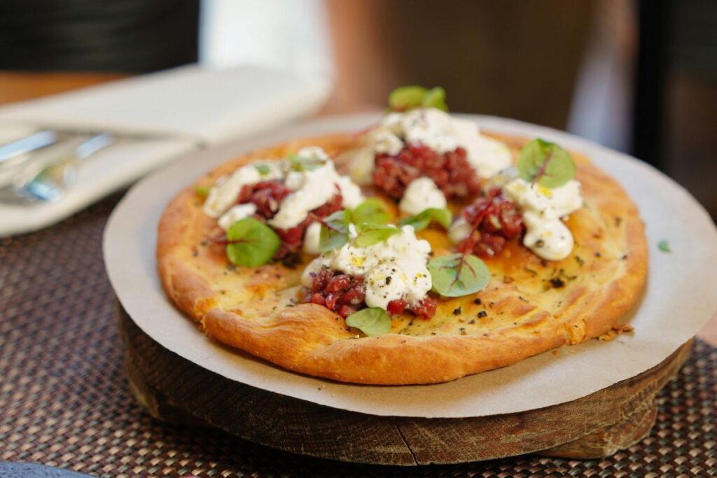 La pizza griega tiene sabores fuertes y mantiene una base gruesa de pan.