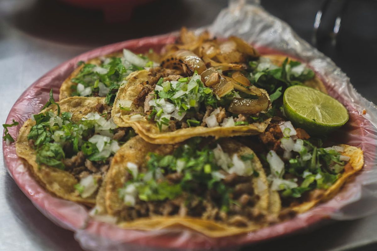 Orden de tacos servidos con cebollas asadas y cilantro. Foto de Pexels.