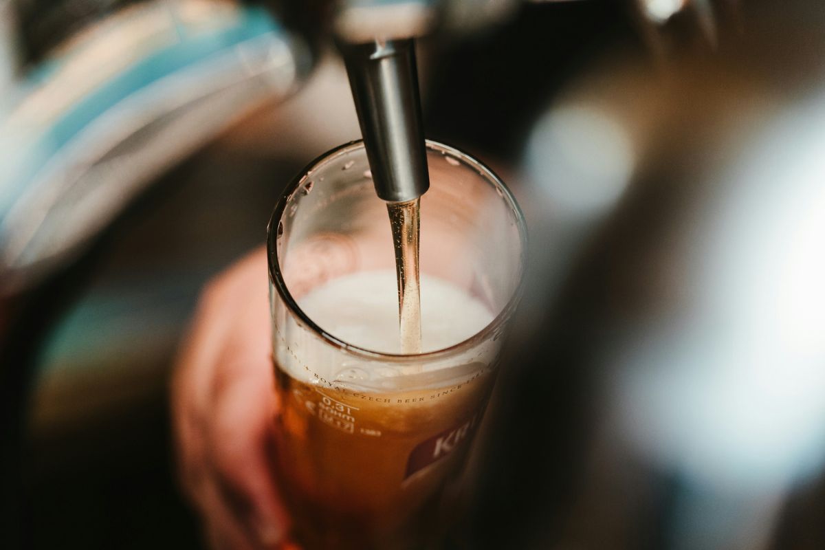 Persona sirviendo cerveza fresca. Foto de Pexels.