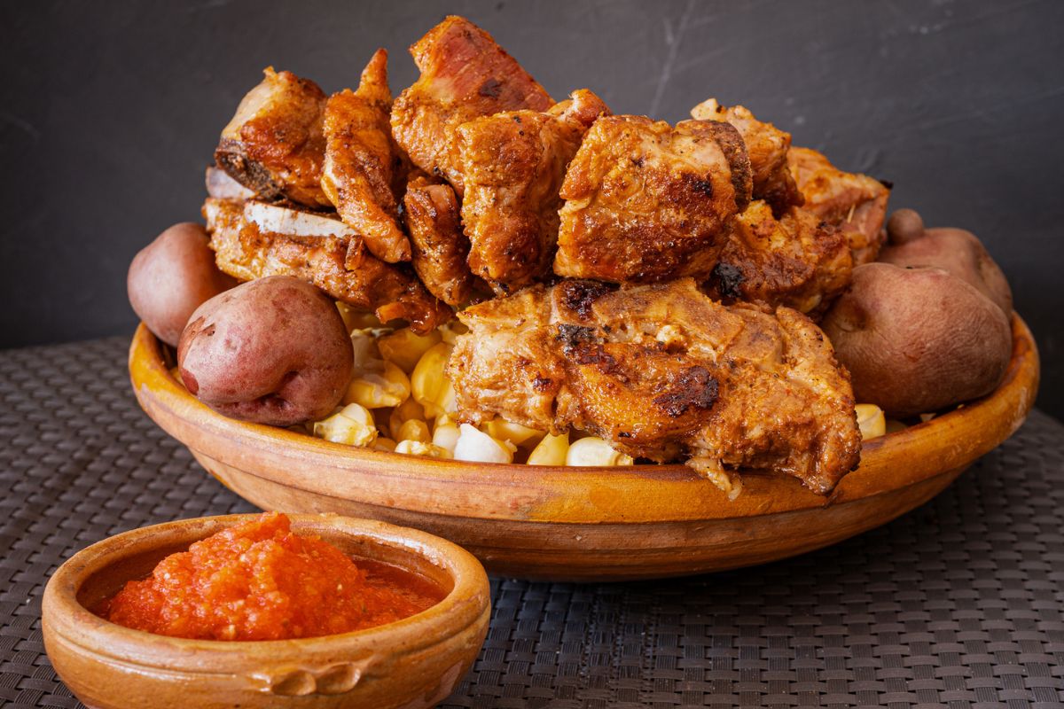 Chicharrón frito de cerdo acompañado de salsa roja. Foto de Pexels.